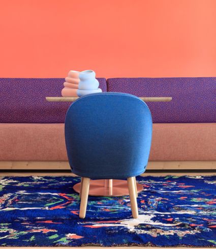 Table with blue chair and colourful rug
