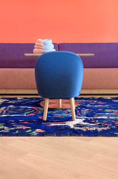 Table with blue chair and colourful rug