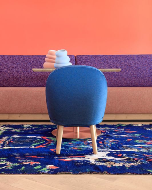 Table with blue chair and colourful rug