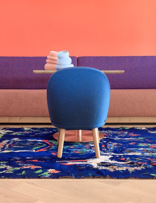 Table with blue chair and colourful rug